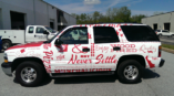 A SUV with a custom business vehicle wrap.