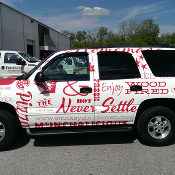 A SUV with a custom business vehicle wrap.