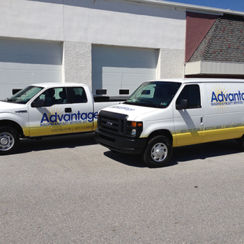 Two work vehicles with matching vehicle wraps for Advantage building services.