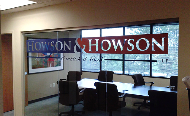 A large custom window graphic on the glass wall of a conference room for Howson & Howson.