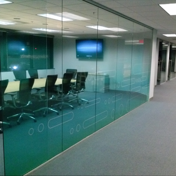 A glass wall to a conference room with subtle window designs.