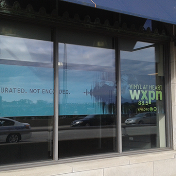 A store front window with window graphics displaying the business name.