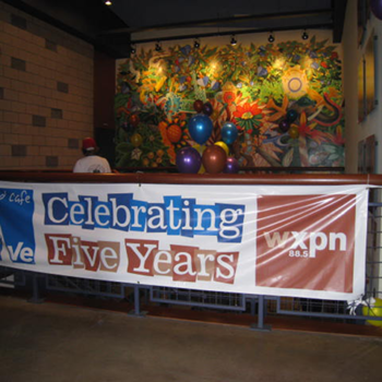 A banner announcing the celebration of five years of business by a radio station.