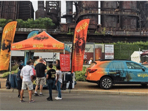 A display booth with matching vehicle for WXPN radio station made by SpeedPro of West Chester.