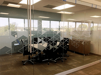 A semi-transparent window graphic on the glass wall of a conference room at a business.