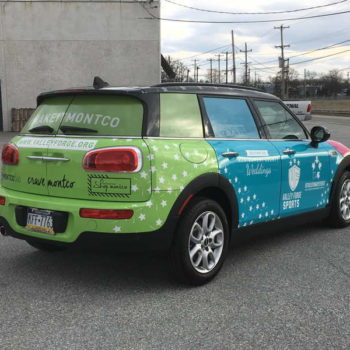 A small car with a customer vehicle wrap made by SpeedPro of West Chester.