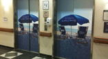 elevator wrap with two blue chairs and umbrella on the beach 