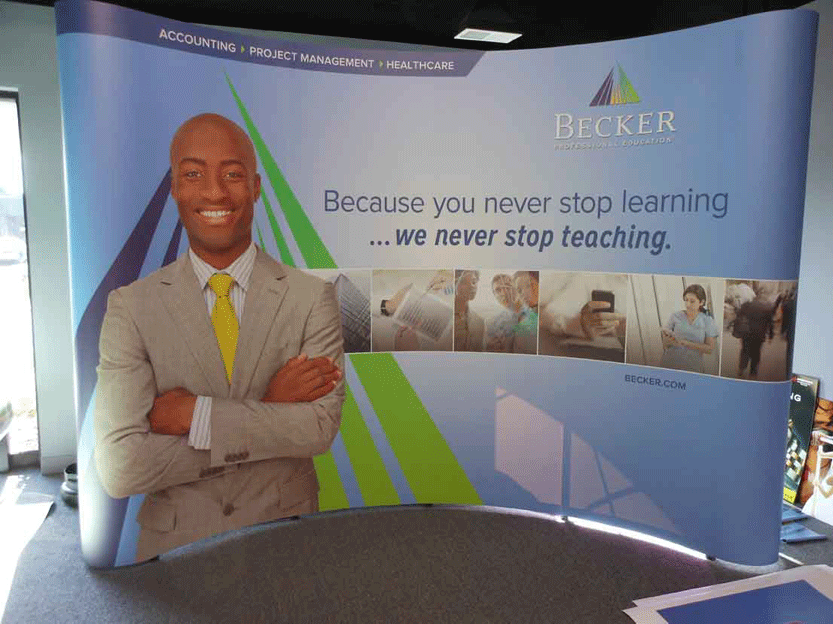 Trade show backdrop for Becker featuring a smiling professional and motivational quote on a blue and green design.