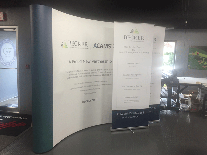 Retractable display banners for Becker Professional Education showcasing project management training information.