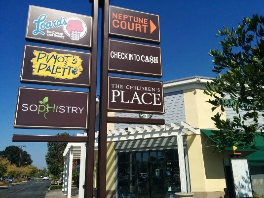 Monument sign with tenant panels for Lord's Ice Cream, Pinot's Palette, Sophistry, Check into Cash, and The Children's Place.