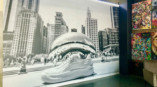 Black and white wall mural featuring a large shoe in front of the Chicago Cloud Gate sculpture.