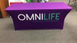Event table throw with purple fabric displaying 'OMNI LIFE' and subtitle 'NUTRITION FOR EVERYONE' in white and green lettering.