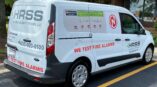 Full van wrap for High Rise Security Systems with white and red graphics displaying contact information and service details.