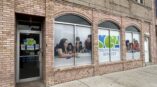 Window graphics for SGA Youth & Family Services featuring vibrant imagery of families engaged in activities.