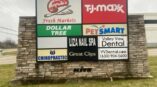 Multi-tenant monument sign with logos for Angelo Caputo's, TJ Maxx, Dollar Tree, PetSmart, and more, on a stone base.