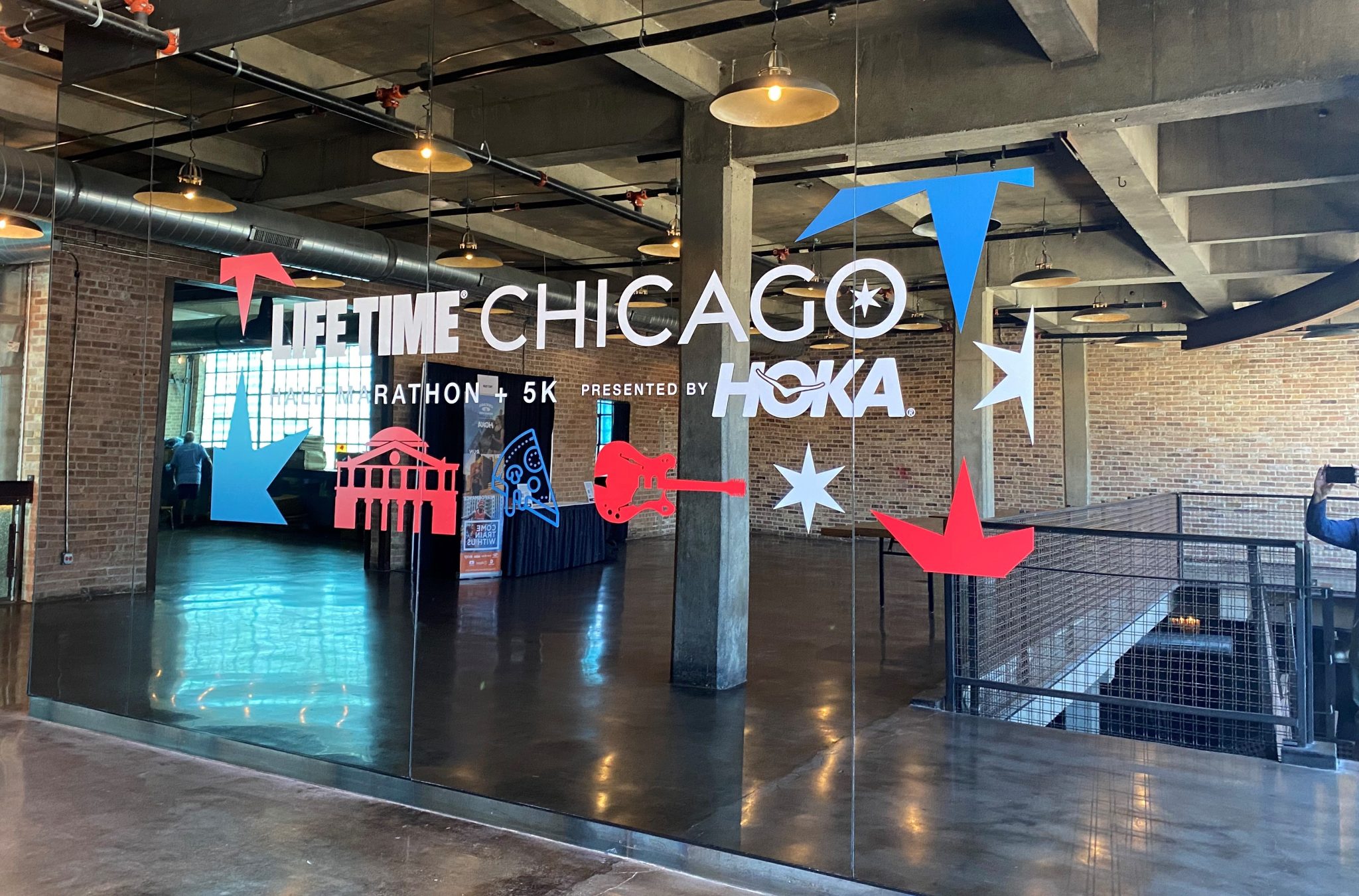 Window graphics for the Lifetime Chicago Marathon + 5K, featuring vibrant red and blue motifs, displayed on a glass wall.