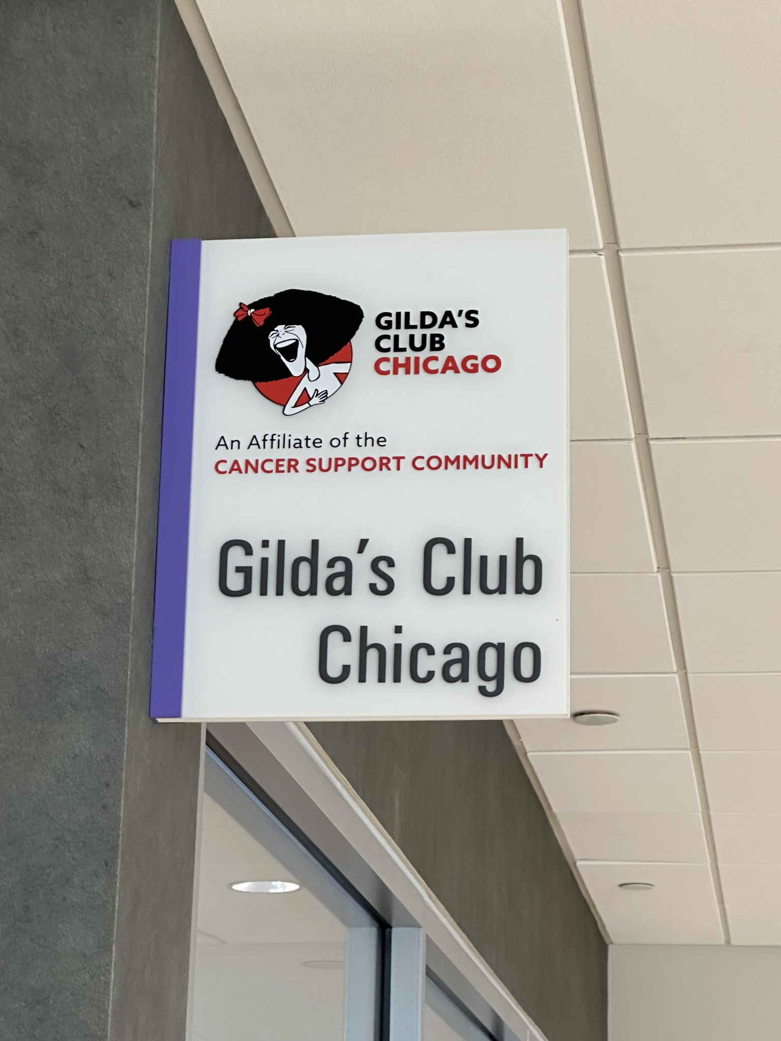Acrylic sign for Gilda's Club Chicago featuring logo and community support message.