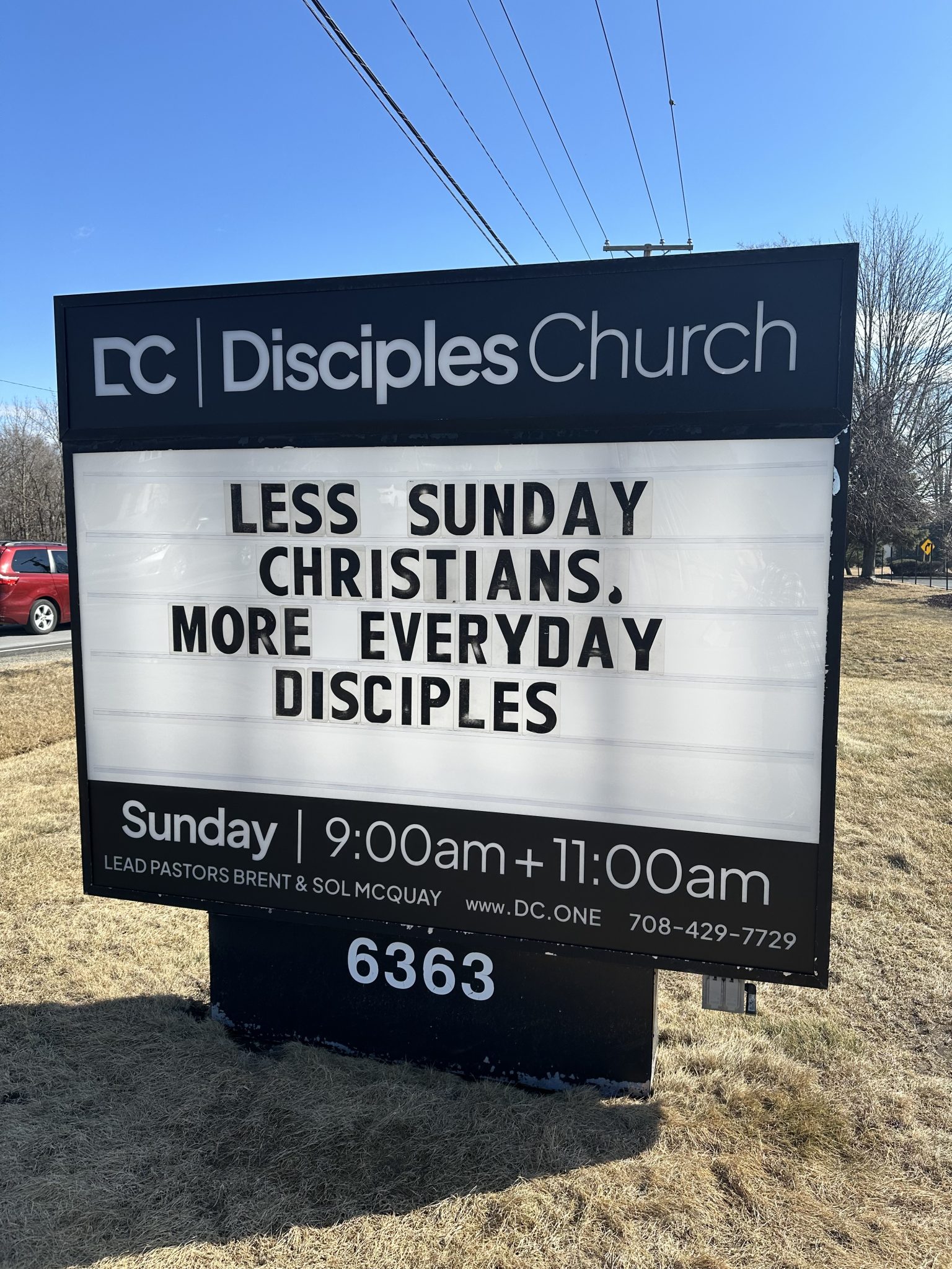 Directional signage for Disciples Church displaying text: 'Less Sunday Christians. More Everyday Disciples' with service times.