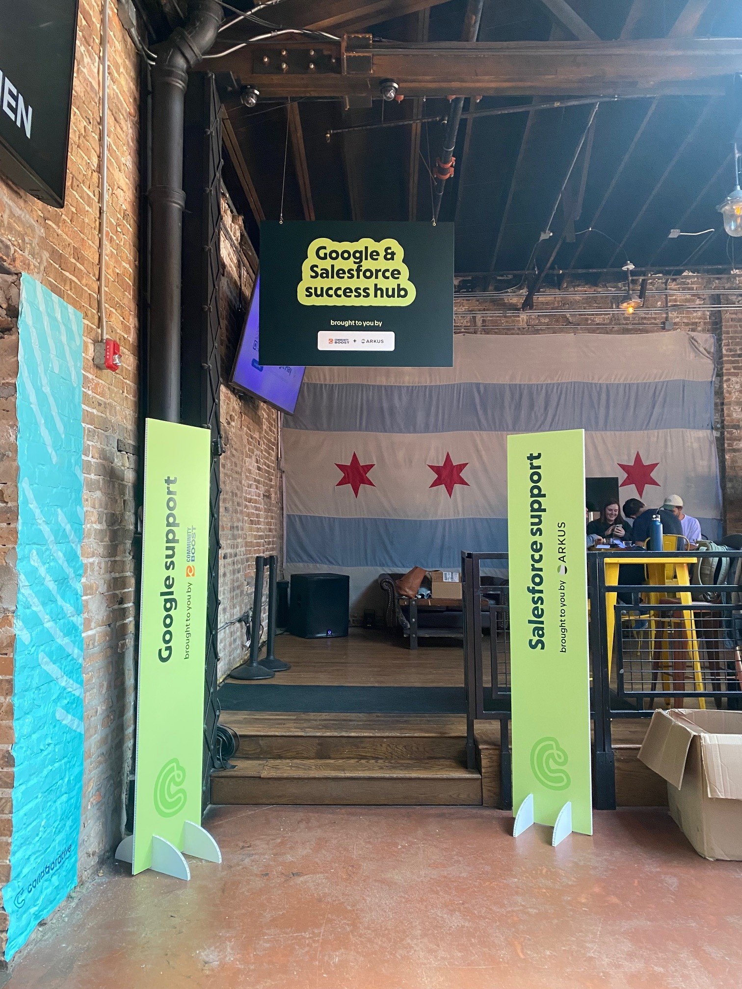 Hanging sign for Google & Salesforce success hub with two vertical wayfinding displays in green.
