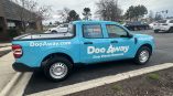 Partial truck wrap for Doo Away dog waste removal service featuring light blue background and bold white text.