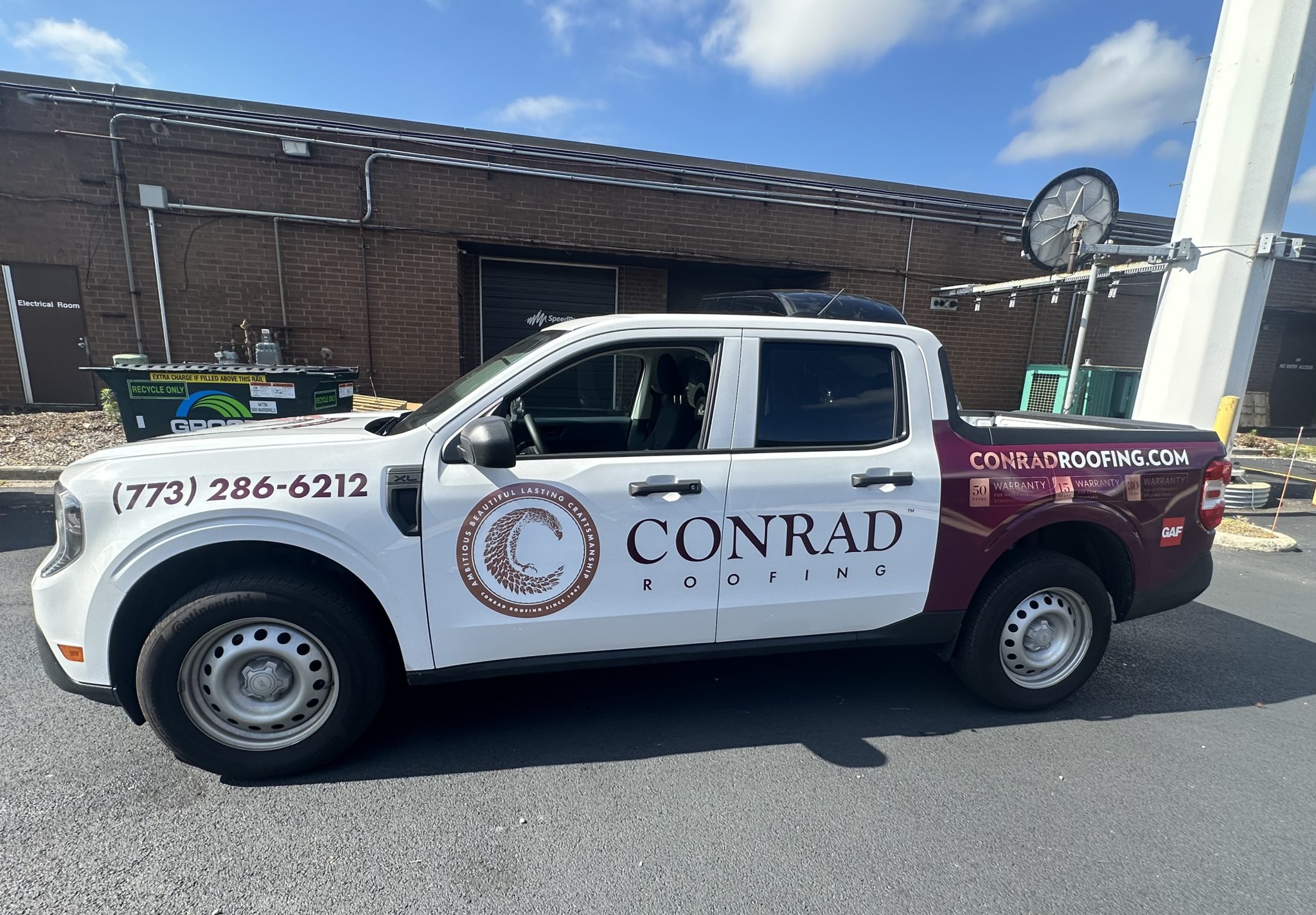Full vehicle wrap for Conrad Roofing with white and maroon graphics, contact information, and logo displayed prominently.