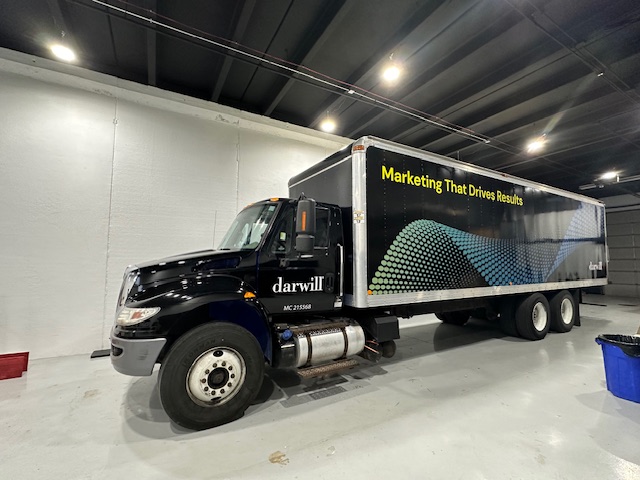 Full truck wrap for Darwill featuring graphic design with colorful dots and the tagline 'Marketing That Drives Results.'