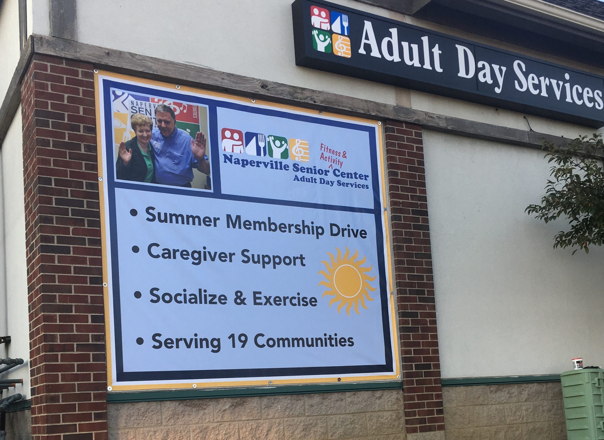 Large outdoor banner for Naperville Senior Center promoting summer membership drive, caregiver support, and social activities.