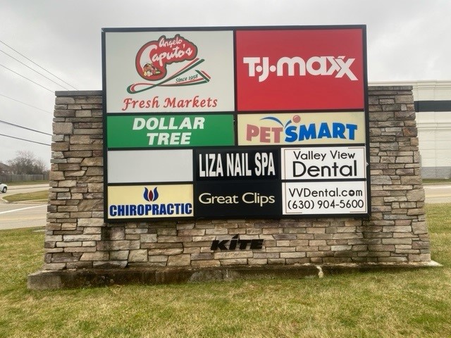 Multi-tenant monument sign featuring businesses like Dollar Tree, PetSmart, and Liza Nail Spa.