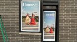 Frosted vinyl window graphics featuring Hennessy branding and Lunar New Year messaging on storefront.