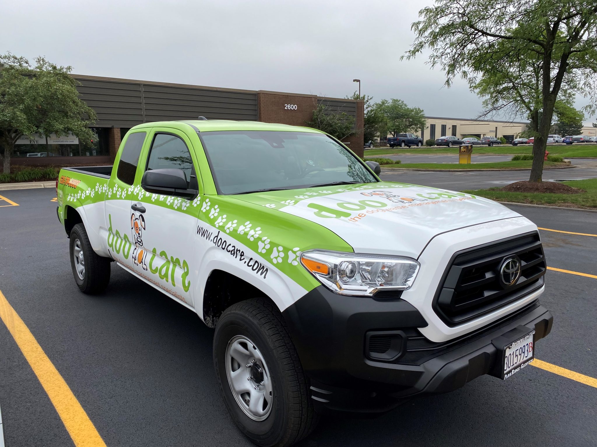 Full vehicle wrap on a Toyota Tacoma for a pet care company, photographed in front of SpeedPro Windy City's Downers Grove production facility on Warrenville Road