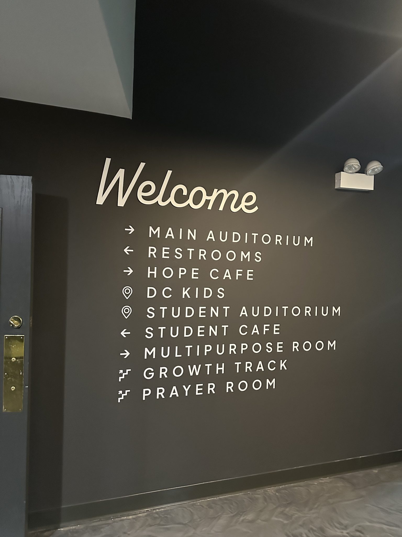 Cut-vinyl Welcome lettering and wayfinding directory decals on a commercial interior wall, installed by SpeedPro Windy City