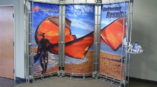 SpeedPro trade show display with person at beach in a wetsuit