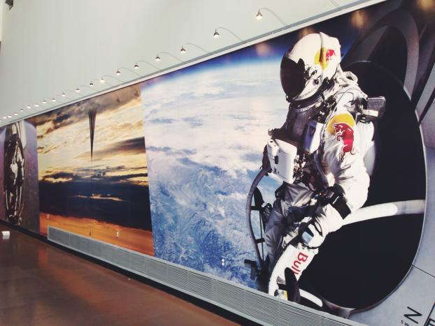 Wall mural of person in Red Bull suit and helmet flying above earth