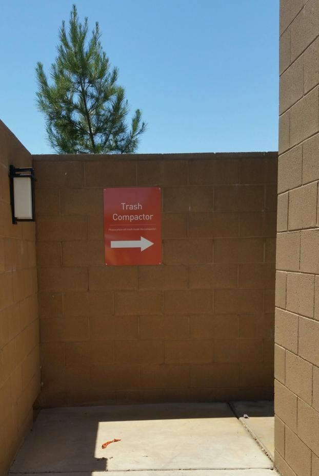 Sign pointing to where the trash compactor is