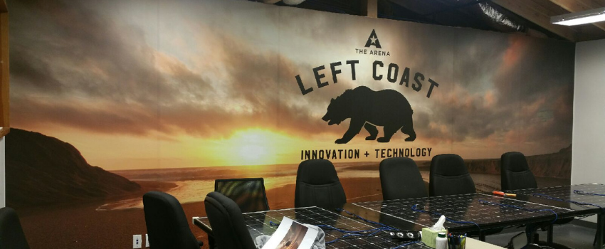 Black conference table with black chairs in front of wall mural for left coast with a bear.