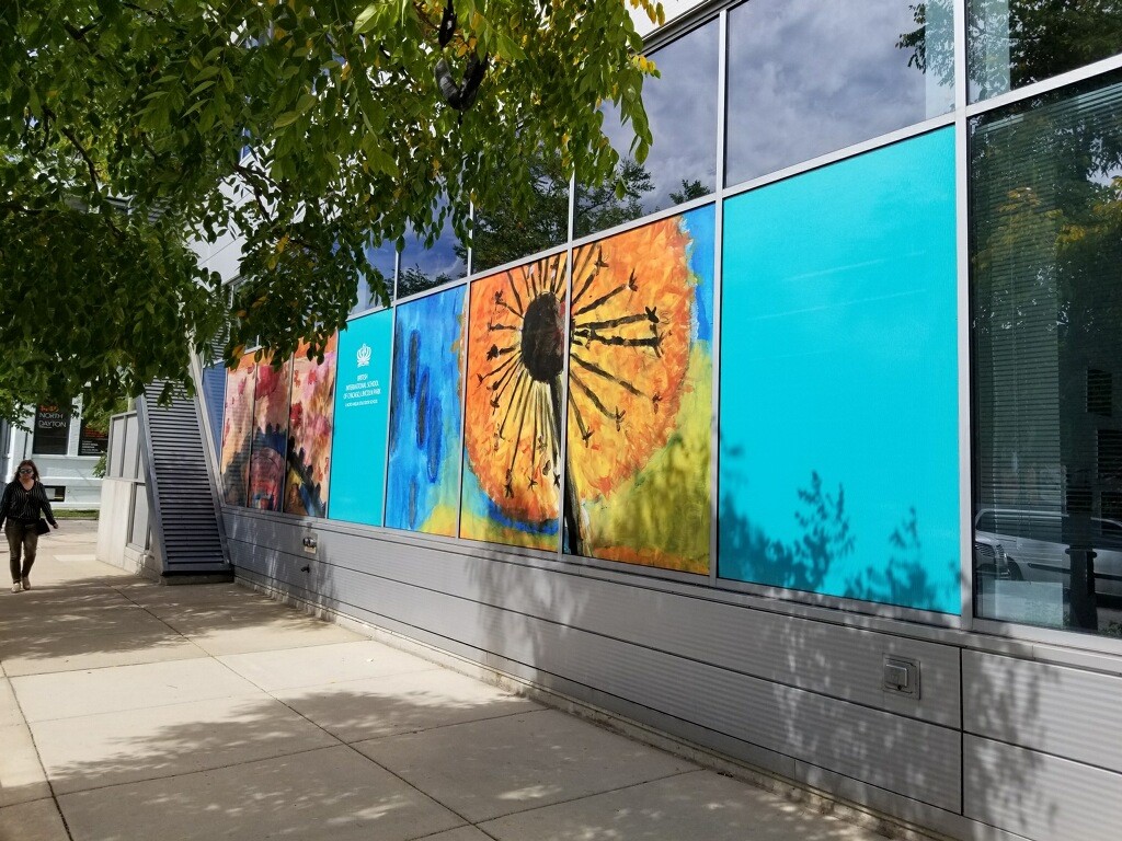 Side of building with blue wall decals and one with a dandelion.