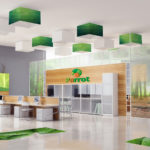 Green and orange parrot logo on tan wall near desks with white screens. 