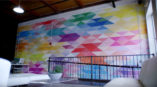 White wall with varying colored triangles.