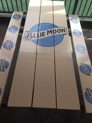 A printed logo for Blue Moon applied to a tabletop